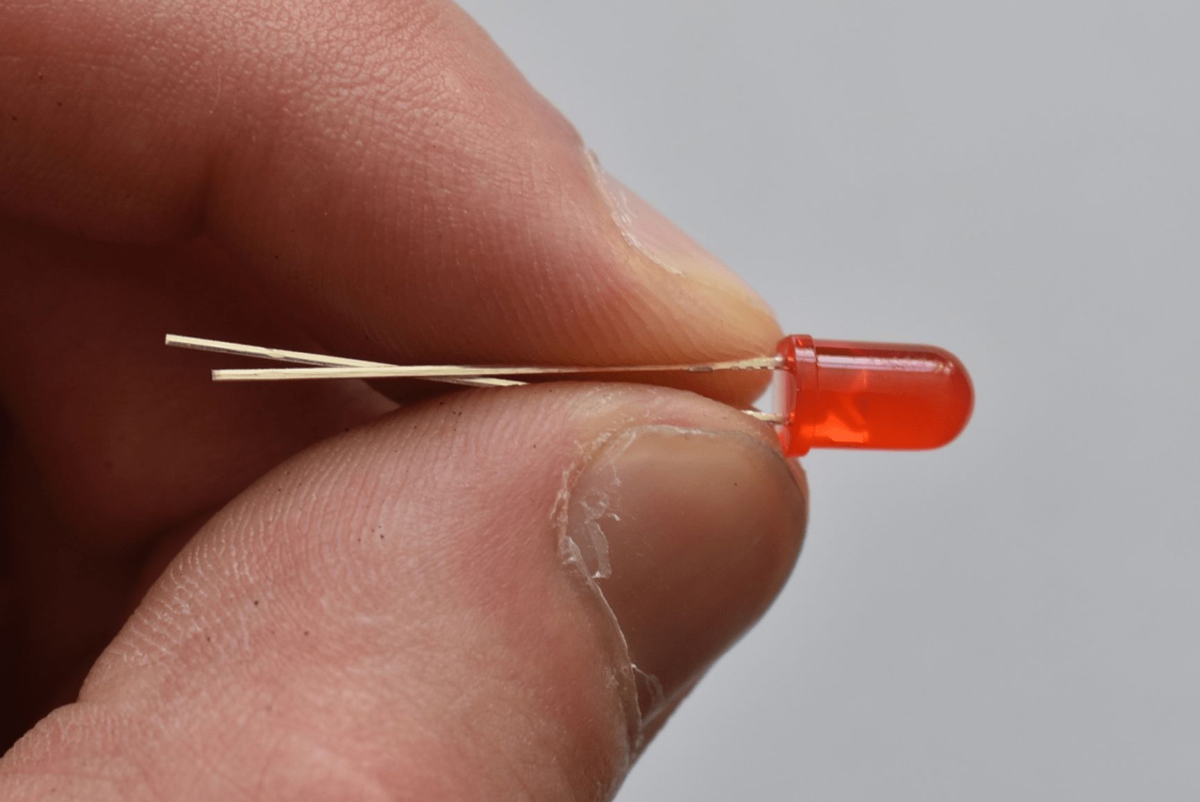 Eine LED wird mit den Fingern so zusammengebogen, dass sich die Beine am Ende überkreuzen