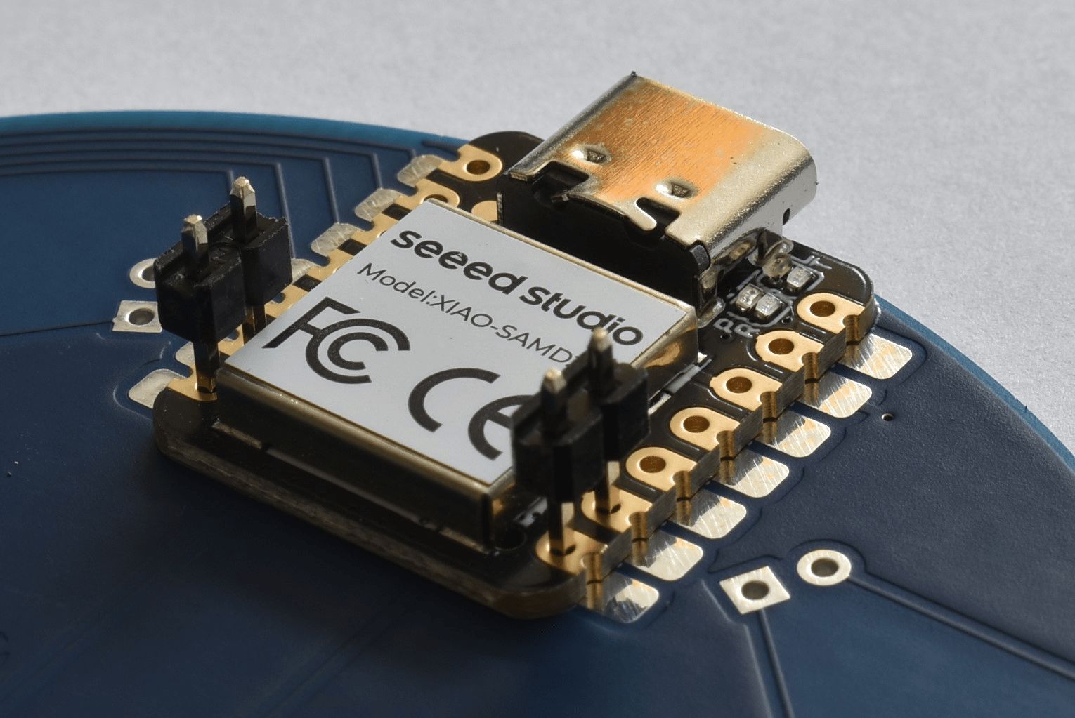 Der Microcontroller liegt auf der Platine auf. Die Stiftleisten stecken links und rechts in den unteren zwei Löchern des Mikrocontrollers.